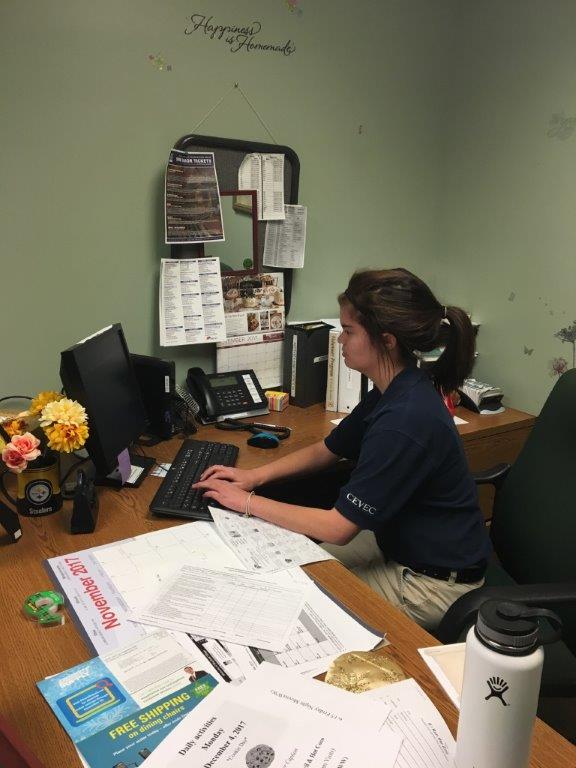 Student working at nursing home desk.
